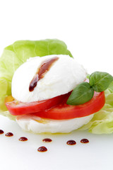 mozzarella e pomodoro con gocce di balsamico su sfondo bianco