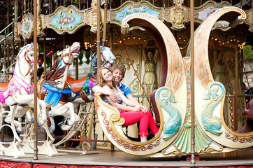 Happy young couple at vintage Parisian merry-go-round