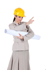 businesswoman holding a blueprint and pointing at something