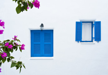 two blue windows on white wall building