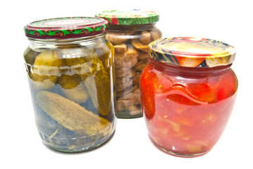 THREE GLASS JARS WITH MARINATED VEGETABLES