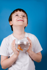 Fototapeta premium Boy holds a fishbowl with a goldfish