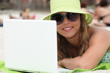Fototapeta na wymiar woman at beach using laptop