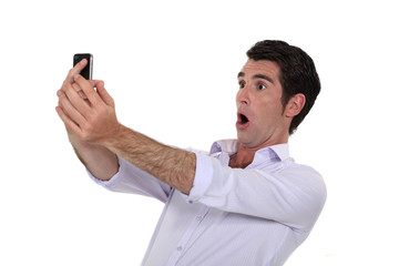 Man surprised watching his mobile phone