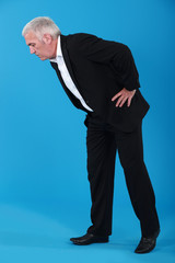 Man bending over to look at something on the floor