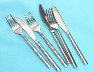 Forks and knives on a blue tablecloth