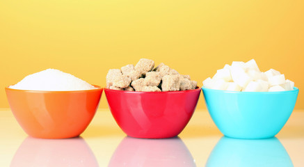 Colorful bowls with different types of sugar