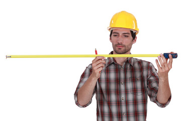 Tradesman using a measuring tape
