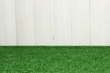 The background of green grass against the white barn