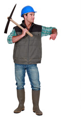 A male construction worker with a pickaxe.
