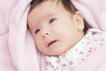 Cute baby with blue eyes lying on the bed