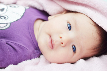 Cute baby with blue eyes looking at camera (2-3 months old)