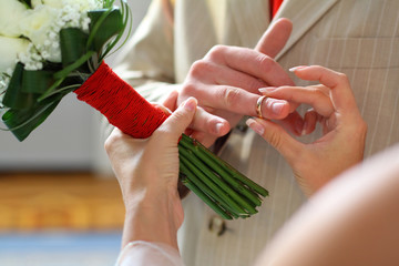 Bride putting a wedding ring on groom's finger