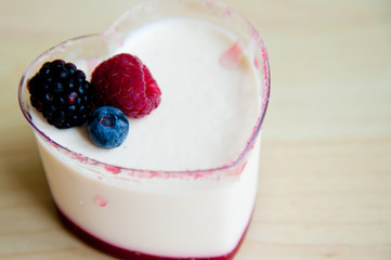 Panna Cotta in heart shape cup on wood pattern background :