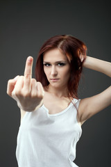 Fototapeta premium Anger young woman in tank top with fuck sign
