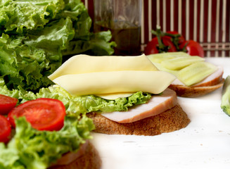sandwiches with cheese slices, tomato, bacon and salad