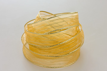 Shiny gold ribbon wrapped in a circle with a white background