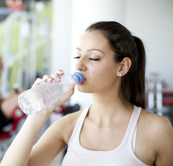 Girl drinking water in the gym