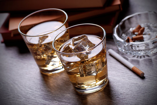 bicchieri di whisky, libri e sigarette
