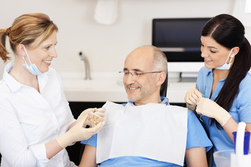 zahnärztin berät einen patienten