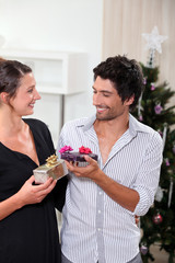 Couple exchanging Christmas gifts