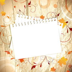 Template at wooden background over maple leaves