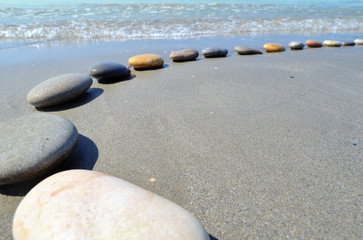 Fototapeta na wymiar Courbe de galets sur le sable