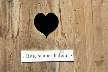 Herz in einer Holztür zum Plumsklo