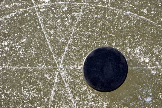 black hockey puck on ice rink