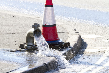 Water being released while a water main is repaired - obrazy, fototapety, plakaty