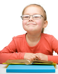 Cute little girl reading book