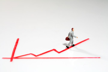 Mini Figur folgt aufsteigendem Graph.