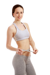 A slim girl measuring her waist, side-view