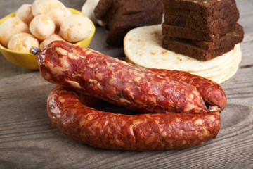 Still-life with sausage and bread on a  table