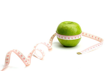 A green apple and a measuring tape