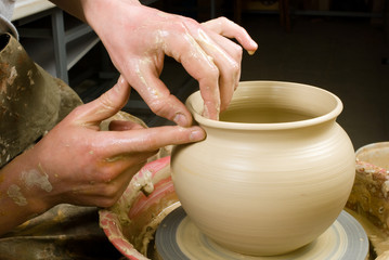 hands of a potter, creating an earthen jar on the circle