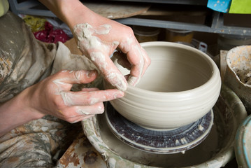 hands of a potter, creating an earthen jar on the circle