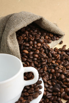 A sack of coffee beans and a cup, closeup