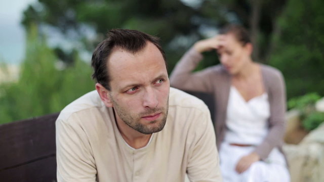 Relationship difficulties, young couple sitting outdoors