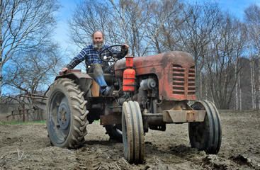 The bearded man sits on a tractor