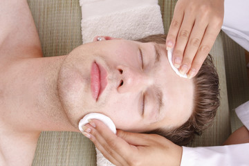 Fototapeta na wymiar Close up of a man receiving facial massage from a woman