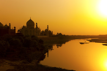 Taj Mahal met de Yamuna-rivier bij zonsondergang, India.