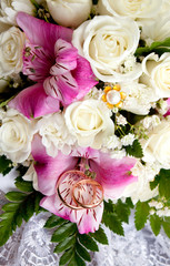 wedding rings of the groom and the bride on a bunch of flowers.
