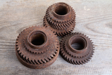 Rusty iron gear wheels on a  boards