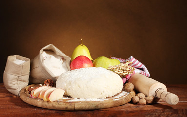 ingredients for homemade pie on wooden table on brown