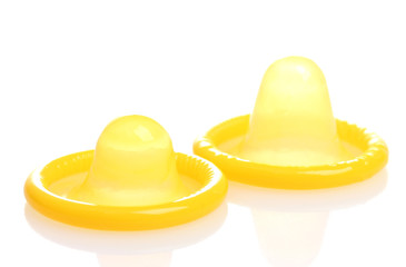 Two yellow condoms isolated on white