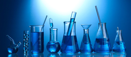 Test-tubes with blue liquid on blue background