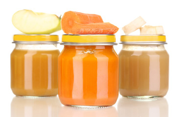 Jars of baby puree with spoon isolated on white