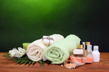 Spa setting on wooden table on green background