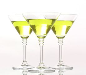 Yellow cocktail in martini glasses isolated on white